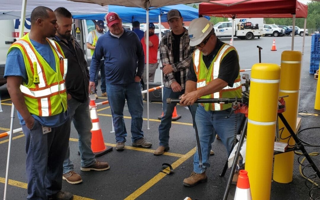 UGI Utilities employees demonstrates safe equipment operation to surrounding group of people.